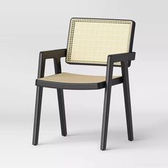 a black and white chair with a woven seat pad on the back, side view