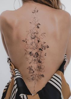 the back of a woman's neck with flowers on it