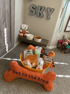 there is a dog bone in the middle of this room with an orange bowl full of treats