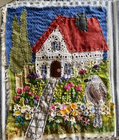 a patchwork quilt with an image of a house and bird in the garden on it