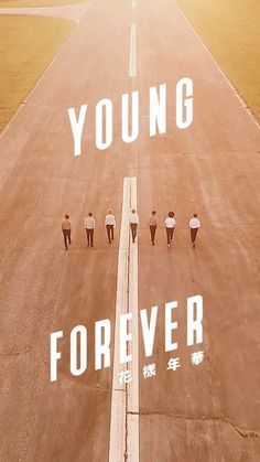 a group of people walking down a road with the words young forever written on it