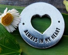 a heart shaped key with the words always in my heart on it next to a flower