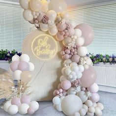 balloons and decorations are arranged on the floor in front of a large sign that says oh baby