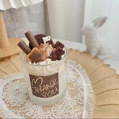 a cup filled with lots of dessert on top of a doily