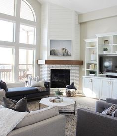 a living room filled with furniture and a fire place in front of a large window