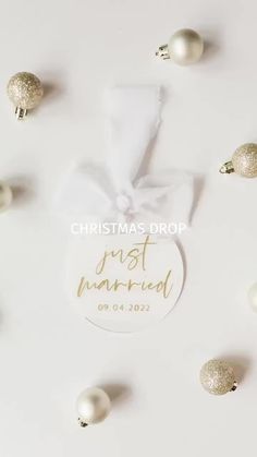 a white ornament with the words just married on it surrounded by christmas ornaments