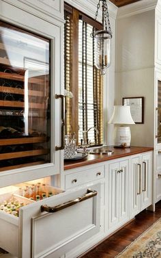 an image of a kitchen with white cabinets and wood counter tops, which are open to the