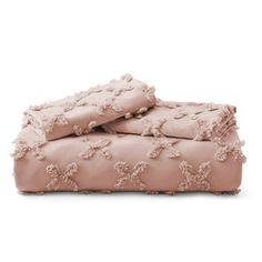 a bed with pink sheets and pillows on top of each other, in front of a white background