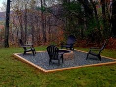 an outdoor fire pit surrounded by lawn chairs and graveled area with trees in the background