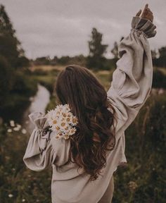 a woman holding a flower in her hand