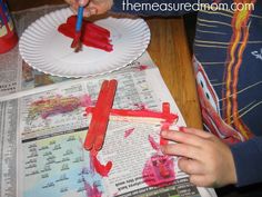 a child is painting on paper plates with crayons