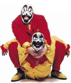 two clowns are sitting on the ground with their mouths open