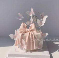 there is a cake that has been decorated with pink flowers and a bow on it