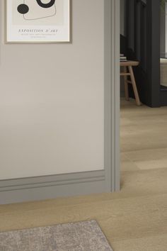 an open door leading to a living room with wood flooring and walls painted in grey