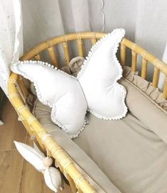 a white butterfly pillow sitting on top of a baby crib