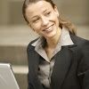 a woman smiling while using a laptop computer