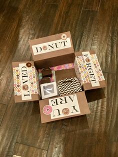 an open cardboard box with various items in it on the floor next to a sign that says donut party mix