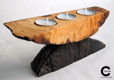 three tealight candles are placed on top of a piece of wood that looks like a log