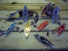 several canoes and kayaks sitting on top of a wooden table next to each other