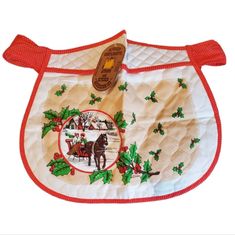 an oven mitt with a horse and holly design on it's front side