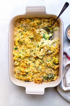 a casserole dish with broccoli, cheese and other toppings in it