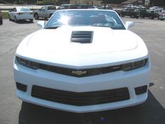 a white sports car parked in a parking lot