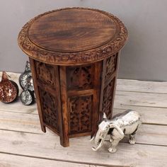 an elephant figurine sitting on top of a wooden table