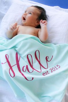 a baby laying on top of a bed under a blanket