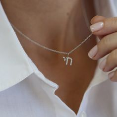 The Chai "ALive" necklace is a symbol of ancient significance for the Jewish people. This necklace has a modern twist with a special modern letters design. The letters are set with a natural white diamonds. The perfect dainty necklace. Pendant HAI size: 8 mm   The length of the solid gold chain is 42 + 3 cm extension = 45 cm For the engraved version of this necklace - https://www.etsy.com/listing/591415993/ For a similar round gold diamond pendant necklace - https://www.etsy.com/listing/58324194 White Gold Necklace With Si Clarity As A Gift, Silver Diamond Necklace Si Clarity Gift, Silver Diamond Necklace With Si Clarity As Gift, Silver Diamond Necklace Si Clarity As Gift, Sterling Silver Diamond Necklace With Initials, Minimalist Silver Diamond Initial Pendant Necklace, Delicate Silver Initials Necklace, Silver Sterling Diamond Necklace With Initials, Silver Pendant Initial Necklace In Fine Jewelry