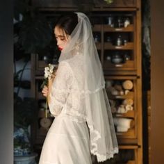 a woman in a wedding dress holding a flower