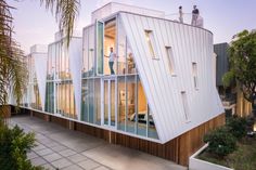 two people are standing on the roof of a house that is shaped like a pyramid