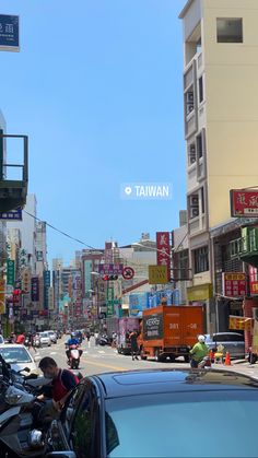 a busy city street filled with lots of traffic and people walking on the side of it