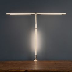 a desk lamp sitting on top of a wooden table next to a blue wall and floor