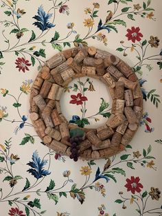 a wreath made out of wine corks sitting on top of a floral wallpaper