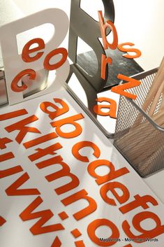 an orange and white sign sitting on top of a table next to a metal basket