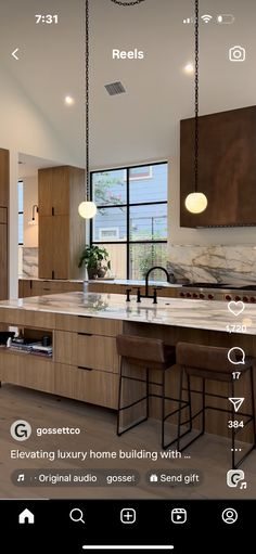 a kitchen with wooden cabinets and an island in front of the window that has lights hanging from it