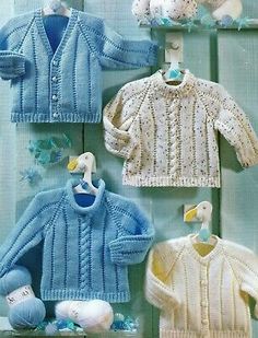 four knitted baby sweaters and ones in blue, white and yellow with ducks on them