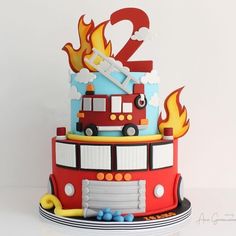 a birthday cake with a firetruck on top and the number two in the middle