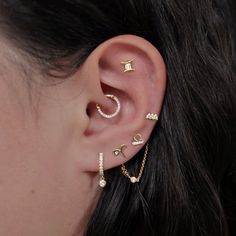 a woman's ear with three different piercings