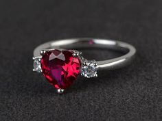 Welcome to my shop, you can find many beautiful gemstone jewelry here, and you also can ask for customized service. Main Stone: 8*8 heart cut lab rubyAccent Stones: czMetal: 925 sterling silver plated with rhodium. I also can provide metal options such as 14k solid yellow/white/rose goldSetting: prong settingMore rings please go to my shop home: https://www.etsy.com/shop/XCjewelryStudio?ref=hdr_shop_menuIt's a perfect gift for who born in July(birthstone),it's quite comfortable for wearing and s Silver Heart-shaped Ruby Ring, Red Heart-shaped Ring With Prong Setting, Heart-shaped Red Ruby Ring With Diamonds, Red Cubic Zirconia Heart Ring For Promise, Red Cubic Zirconia Heart Promise Ring, Heart Cut Lab-created Ruby Ring, Heart-shaped Red Ruby Ring In Sterling Silver, Heart Shaped Ruby Ring With Accent Stones, Red Heart Cut Ruby Ring With Accent Stones