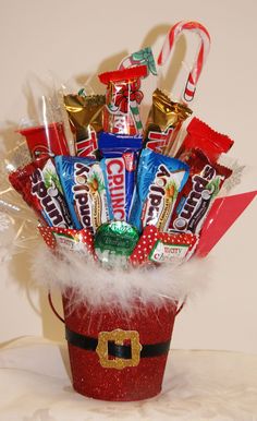 a bucket filled with candy and candies sitting on top of a table next to a white wall