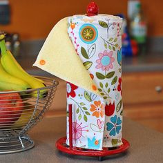 some bananas and apples in a bowl on a counter top next to a napkin dispenser