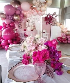 a table set for a party with balloons and flowers