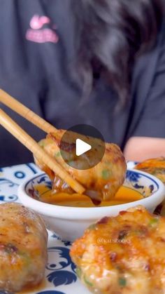 a person sitting at a table with some food in front of them and chopsticks sticking out of it