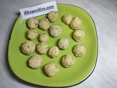 a green plate filled with cookies on top of a white tablecloth next to a sign