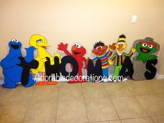 a group of sesame street characters standing in front of the word hola spelled out