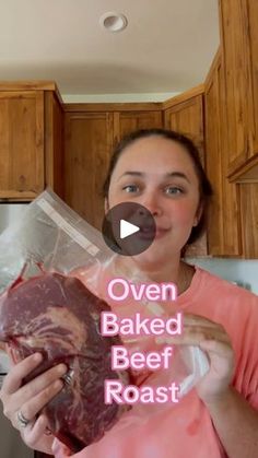 a woman holding up a piece of meat in her kitchen with the words oven baked beef roast