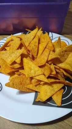 a white plate topped with chips on top of a wooden table