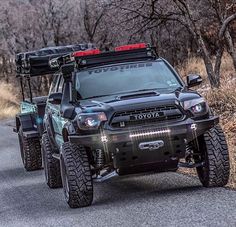 two off - road vehicles driving down a country road