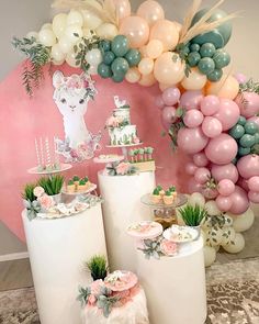 a table topped with lots of balloons and cake on top of white cylinder vases